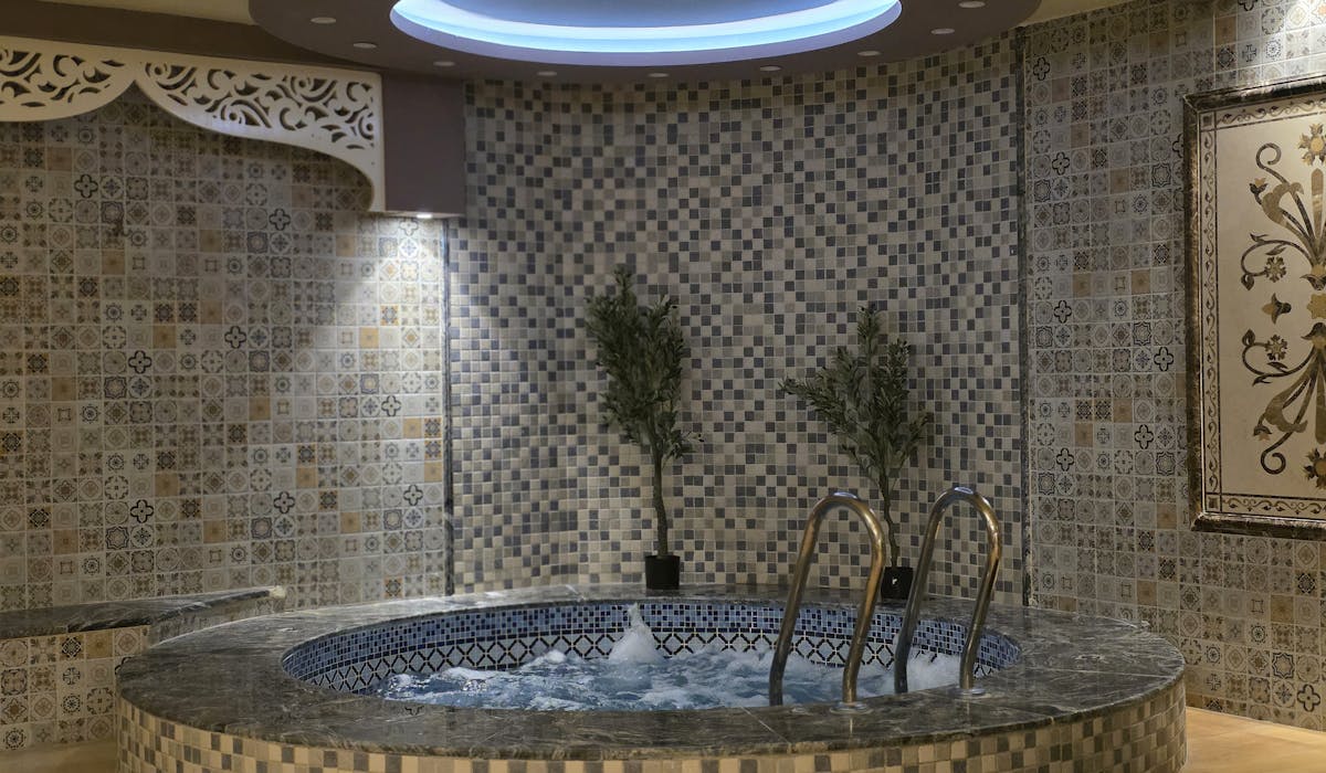 Ornate mosaic tile spa room — wet area tile installation